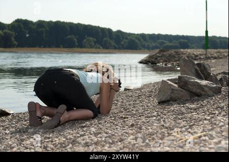 Eine junge Frau, die Fotos am Rheinufer macht Stockfoto