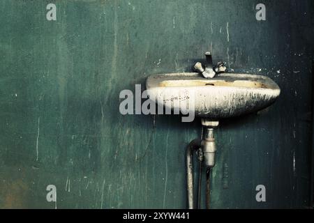 Altes, dreckiges Waschbecken in einer verlassenen Fabrik Stockfoto