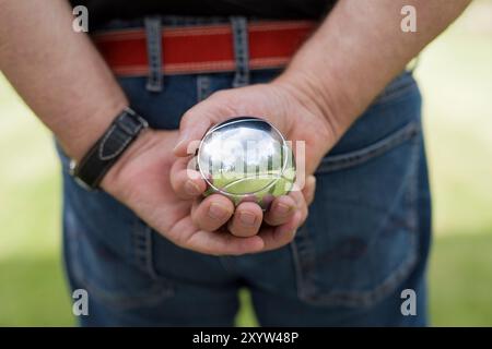 Boulespieler hält seinen Bouleball in der Hand Stockfoto