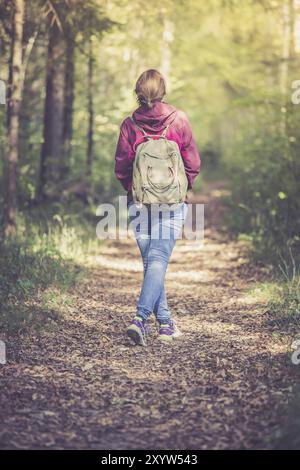 Junge Frau geht im Frühling durch den Wald Stockfoto
