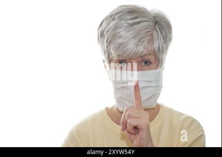 Frau mit Gesichtsmaske und erhobenem Zeigefinger Stockfoto