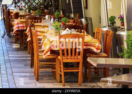 Blick auf die Altstadt von Nafplio, Griechenland, mit bunten Tischen und Stühlen im Straßenrestaurant in Nafplion, Peloponnes Stockfoto