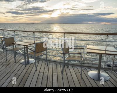 Terrasse am Meer bei Sonnenuntergang, leere Tische und Stühle, ruhige Atmosphäre, svaneke, bornholm, ostsee, dänemark, skandinavien Stockfoto