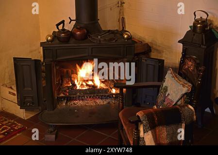 Europa, Deutschland, Kamin, Ofen, Typ Franklin, im Wohnzimmer, Stuhl am Kamin, Hamburg, Hamburg, Bundesrepublik Deutschland, Europa Stockfoto