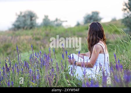 Frau zurück sitzen im Gras. Ansicht von hinten. Konzept Foto Stockfoto