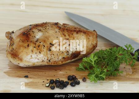 Geflügelfleisch, gebratenes putensteak auf Holzbrett mit Messer, Kräutern und Pfeffer Stockfoto