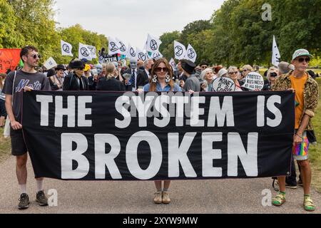 Windsor, Großbritannien. 30. August 2024. Klimaaktivisten der Extinction Rebellion inszenieren einen Protest „das System ist gebrochen“ auf dem langen Spaziergang vor Windsor Castle am ersten von drei Tagen der „Upgrade Democracy“-Aktivitäten. Die Kampagne „Upgrade Democracy“ von Extinction Rebellion soll die Art und Weise hervorheben, wie die Gewinne der Öl- und Gasunternehmen im Vereinigten Königreich gesichert werden, und die britische Regierung auffordern, eine Bürgerversammlung für Klima- und ökologische Gerechtigkeit zu gründen und von ihr geleitet zu werden. Quelle: Mark Kerrison/Alamy Live News Stockfoto