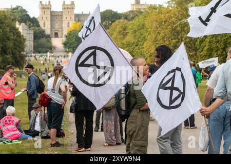 Windsor, Großbritannien. 30. August 2024. Klimaaktivisten der Extinction Rebellion versammeln sich auf dem langen Spaziergang vor Windsor Castle zu einem „das System ist gebrochen“-Protest am ersten von drei Tagen der „Upgrade Democracy“-Aktivitäten. Die Kampagne „Upgrade Democracy“ von Extinction Rebellion soll die Art und Weise hervorheben, wie die Gewinne der Öl- und Gasunternehmen im Vereinigten Königreich gesichert werden, und die britische Regierung auffordern, eine Bürgerversammlung für Klima- und ökologische Gerechtigkeit zu gründen und von ihr geleitet zu werden. Quelle: Mark Kerrison/Alamy Live News Stockfoto