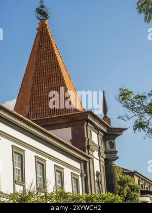 Detaillierte Ansicht eines historischen Gebäudes mit einem spitzen roten Dach unter klarem Himmel, Funchal, madeira, portugal Stockfoto