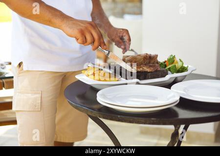 Mann Kochen Beaf Steak auf dem heissen Stein. Grill im freien Stockfoto