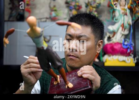 (240831) -- ZHENGZHOU, 31. August 2024 (Xinhua) -- Song Zhanke macht eine Teigskulptur der chinesischen mythologischen Figur des Affenkönigs oder Sun Wukong in seinem Atelier in Luoyang, Zentralchinas Provinz Henan, 27. August 2024. Das Teighandwerk nimmt Weizen und klebriges Reismehl als Hauptbaustoffe, die mit Öl, Salz, Essig und anderen Zutaten vermischt werden. Mithilfe von Händen und einfachen Werkzeugen knetscht und knickt ein Künstler den Teig, um ihn in komplizierte und lebensechte Figuren zu verwandeln. Song Zhanke, 46, ist ein Erbe von Song's Teig-Skulptur, einem bekannten Teighandwerk in Luoyang. Ich habe Li Stockfoto