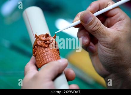 (240831) -- ZHENGZHOU, 31. August 2024 (Xinhua) -- Song Zhanke fertigt eine Teigminiatur der Rüstung der chinesischen mythologischen Figur des Affenkönigs oder Sun Wukong in seinem Atelier in Luoyang, Zentralchinas Provinz Henan, 27. August 2024. Das Teighandwerk nimmt Weizen und klebriges Reismehl als Hauptbaustoffe, die mit Öl, Salz, Essig und anderen Zutaten vermischt werden. Mithilfe von Händen und einfachen Werkzeugen knetscht und knickt ein Künstler den Teig, um ihn in komplizierte und lebensechte Figuren zu verwandeln. Song Zhanke, 46, ist ein Erbe von Song's Teig-Skulptur, einem bekannten Teighandwerk in Luoyang. Stockfoto