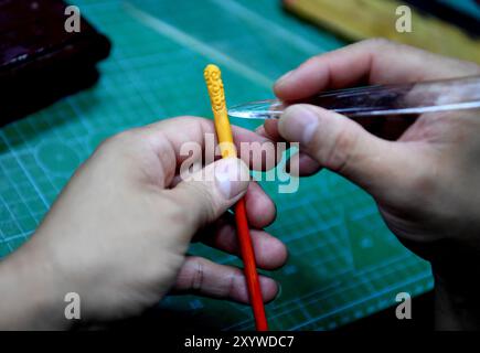 (240831) -- ZHENGZHOU, 31. August 2024 (Xinhua) -- Song Zhanke macht eine Teigminiatur von Jingubang, der Waffe der chinesischen mythologischen Figur der Affenkönig oder Sun Wukong, in seinem Atelier in Luoyang, Zentralchinas Provinz Henan, 27. August 2024. Das Teighandwerk nimmt Weizen und klebriges Reismehl als Hauptbaustoffe, die mit Öl, Salz, Essig und anderen Zutaten vermischt werden. Mithilfe von Händen und einfachen Werkzeugen knetscht und knickt ein Künstler den Teig, um ihn in komplizierte und lebensechte Figuren zu verwandeln. Song Zhanke, 46, ist ein Erbe von Song's Teigskulptur, einem bekannten Teighändiker Stockfoto