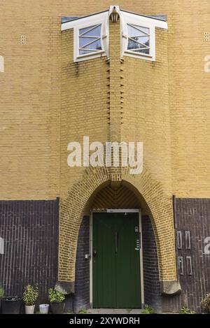 Amsterdam, Niederlande. Juni 2022. Details und Fassaden der charakteristischen Backsteinkonstruktion des Wohngebäudes in Amsterdam Schule Stil architec Stockfoto