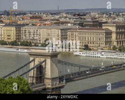 Blick auf die Stadt mit einer Brücke über einen Fluss, umgeben von historischen Gebäuden und Verkehr, budapest, donau, ungarn Stockfoto