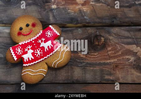 Lächelnde weihnachts-Lebkuchenmenschen auf hölzernem Hintergrund Stockfoto