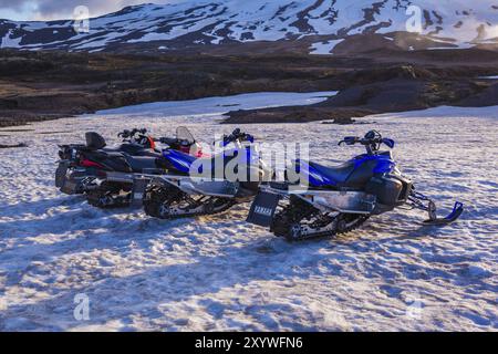 ISLAND, 4. JULI: Vier Schneemobile parkten in einer Reihe in dickem Winterschnee in Island in einer einsamen eiskalten winterlichen Landschaft am 4. Juli 2013 in I Stockfoto