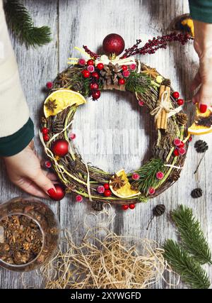 Weihnachten handgefertigte Kranz in jungen womans Hände. Winterurlaub feier Konzept Stockfoto