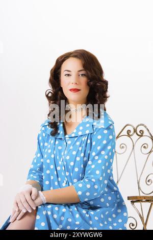 Elegant gekleidete Frau in blauem Mantel mit weißen Polka Dots Stockfoto