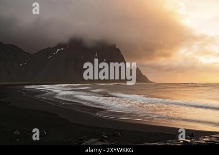 Vestrahorn Berg und der schwarze Strand bei Sonnenaufgang an einem bewölkten Tag, Island, Europa Stockfoto