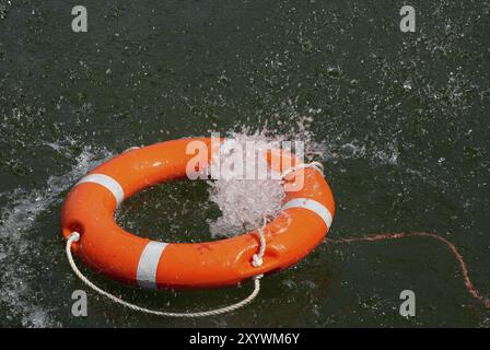 Roter Rettungsring mit Rettungsleine im Wasser, Seenot auf See, Ertrinken, Unfall, Gefahr, Schifffahrt, Seefahrt, Rettung, Spritzwasser, Hamburg, Hamburg, Stockfoto