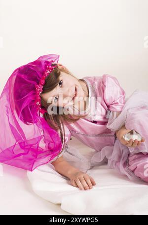 Das kleine Mädchen spielt Prinzessin in einem rosa Kostüm Stockfoto