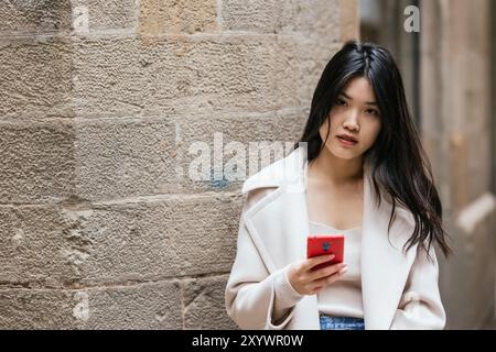 Junge chinesin mit Smartphone in barcelona Stockfoto