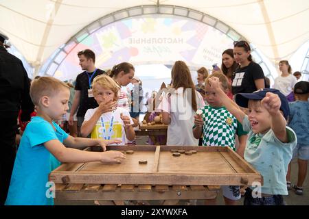 Wladiwostok, Russland. 31. August 2024. Kinder spielen ein Brettspiel während einer Veranstaltung zum Wissenstag in Wladiwostok, Russland, 31. August 2024. Der Wissenstag fand am Samstag in Wladiwostok statt, um den Beginn des neuen Schuljahres zu feiern. Die Veranstaltung mit Sport, Kunst und Spielen zog viele Kinder an. Guo Feizhou/Xinhua/Alamy Live News Stockfoto