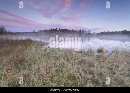 Sonnenaufgang über dem See am kalten Herbstmorgen, Friesland, Niederlande Stockfoto