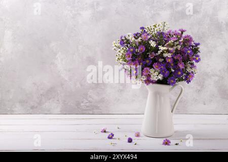 Blumenstrauß aus bunten aster Blüten in einem Krug auf White vintage Hintergrund mit Kopie Raum Stockfoto