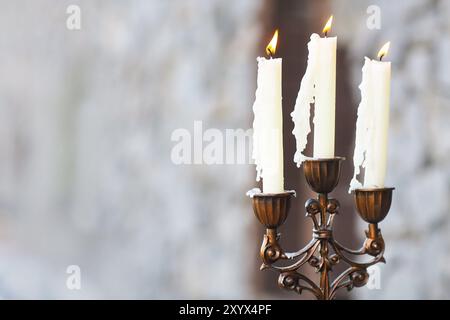 Armleuchter mit drei Kerzen auf grauem Hintergrund blured Stockfoto