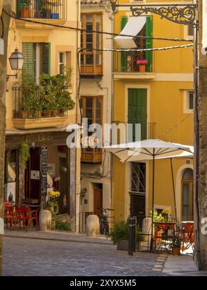 Charmante Gasse mit bunten Gebäuden und einem gemütlichen Gassen-Café unter Sonnenschirmen, palma de mallorca, mallorca, balearen, spanien Stockfoto