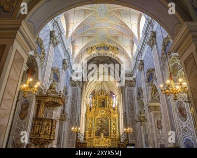 Prächtiges Inneres einer barocken Kirche mit reich verziertem Altar und Deckengemälden, beleuchtet von Kronleuchtern, Duernstein, Wachau, Danub Stockfoto