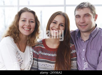 Glückliche Familie lächelnd zusammen mit Tochter im Teenageralter Stockfoto