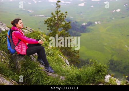 Wanderer mit Rucksack auf einem Berg entspannen und genießen Talblick bei Sonnenaufgang Stockfoto