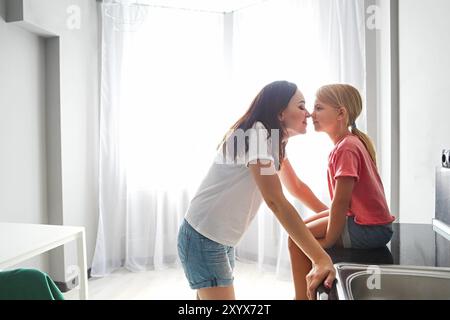 Mutter und Tochter Nase an Nase auf moderne Küche Hintergrund Stockfoto