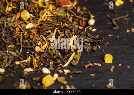 Aromatisierter Tee mit natürlichen getrockneten Blüten, grüner Blatttee gemischt mit Rose und Jasmin Blumen in der Nähe Stockfoto