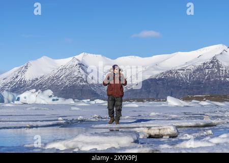 Ein Wanderer spaziert um den gefrorenen See des Jokulsarlon-Gletschers in Island Stockfoto