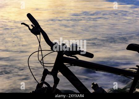 Silhouette von Fahrrad am Strand bei Sonnenuntergang Stockfoto