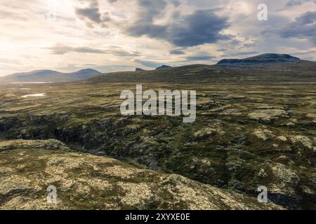 Atemberaubende Aussicht aus der Vogelperspektive auf das zerklüftete Gelände und die Schlucht des Store Ramshøgda im Rondane Nationalpark bei hellem Sonnenlicht, natürliche Schönheit Norwegens Stockfoto
