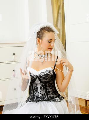 Frau in extravagantem Hochzeitskleid mit schwarzer Spitze Stockfoto