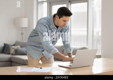 Konzentrierter beschäftigter junger lateinamerikanischer Freiberufler, der zu Hause arbeitet Stockfoto