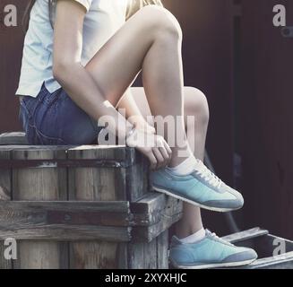 Blaue Sneakers für Mädchen Beine auf dem Grunge Hintergrund. Nahaufnahme Stockfoto