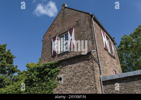 Backsteinbau mit rot-weißen Fensterläden vor blauem Himmel, Xanten, Niederrhein, Nordrhein-Westfalen, Deutschland, Europa Stockfoto