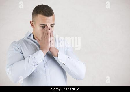 Mann leidet unter eines Stress-Angriffs, isoliert in grau Stockfoto