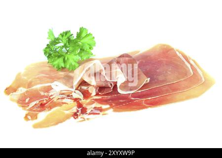 Serrano-Schinken mit Petersilie auf weißem Hintergrund Stockfoto