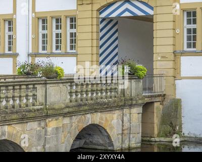 Nahaufnahme des Eingangsbereiches eines Renaissanceschlosses mit Blumenarrangements und Wassergraben, Schloss Neuhaus, Deutschland, Europa Stockfoto