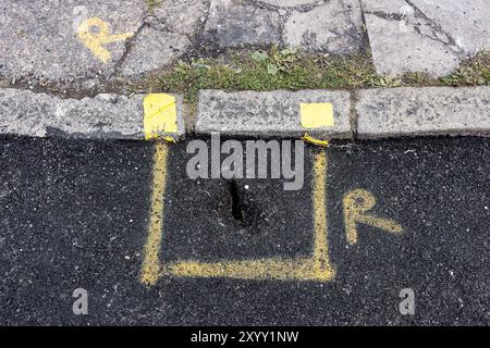 Exeter, Großbritannien. 31. August Sind diese Straßenreparaturen in Exeter die schlimmsten in Großbritannien? Die Bewohner der Ebrington Road in Exeter waren schockiert und ungläubig über den Zustand der Straßenreparaturen, die von Bauunternehmern im Auftrag des Devon County Council (DCC) durchgeführt wurden. Die schlechte Verarbeitung beinhaltete das Tarmern über einem Abfluss, das Tarmern um geparkte Autos und das schlechte Finishing um Mannlochabdeckungen, was die Anwohner beunruhigt hat, da sie eine Stolpergefahr darstellen! Die Arbeiten wurden am 12. August begonnen und abgeschlossen, wobei DCC versprach, die Arbeiten bald abzuschließen… Detail des gedeckten drian durch Asphalt. Stockfoto