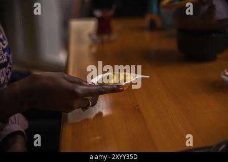 Die Hand hält die weiße Schüssel mit Zitronenscheiben Stockfoto