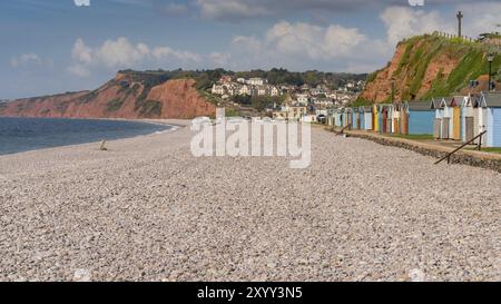 Budleigh Salterton, Jurassic Coast, Devon, England, Vereinigtes Königreich, 19. April 2017: der Kiesstrand mit einigen Strandhütten und das Dorf im Hintergrund Stockfoto